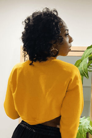 The solid yellow back of the long sleeve crop crewneck sweatshirt.