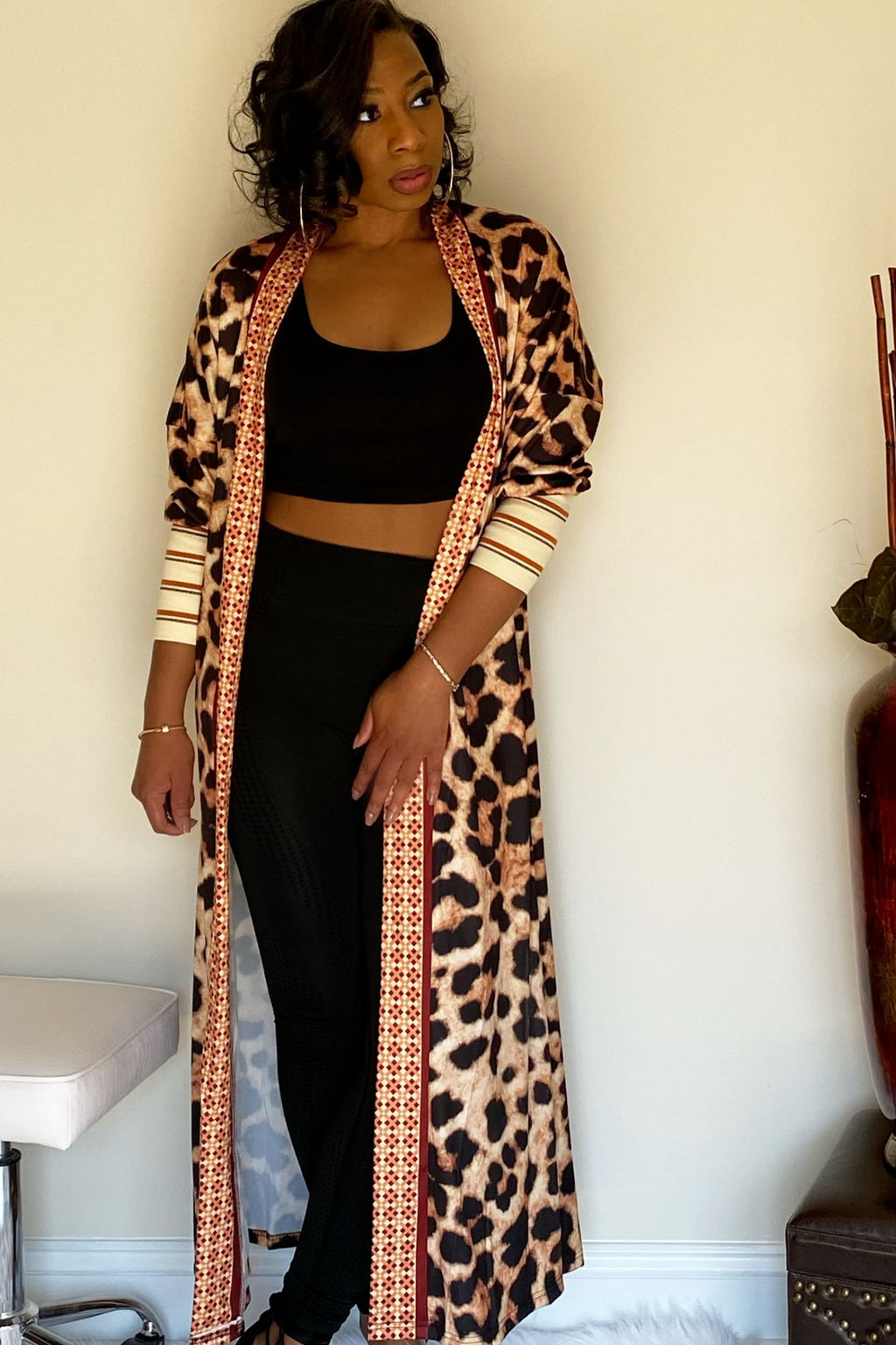 Full length animal print cardigan with three quarter sleeves paired with a black two piece set.. The end sleeves have nude color block with red and black stripe detailing.