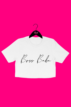 The front view of the whit short sleeved crop t-shirt. The t-shirt has the words boss babe written in black cursive letters across the middle. The shirt stops about 6 inches up from the belly button. The shirt was paired with black distressed jeans.