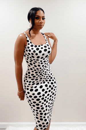 Front view of scoop neck, sleeveless, form fitted, white midi dress with black polka dots.